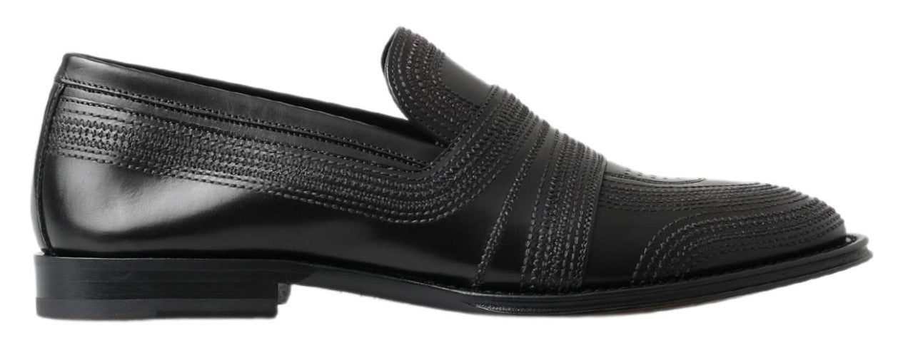 Black leather slipper loafers with stitched detailing from Dolce & Gabbana, showcasing a sleek, classic shoe design.
