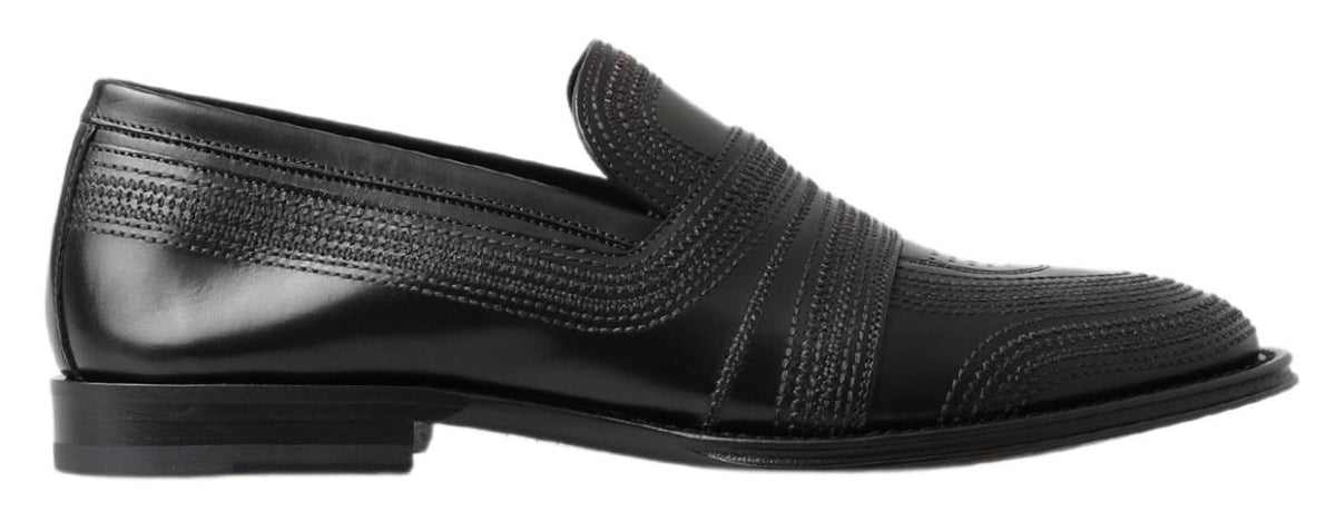 Black leather slipper loafers with stitched detailing from Dolce & Gabbana, showcasing a sleek, classic shoe design.