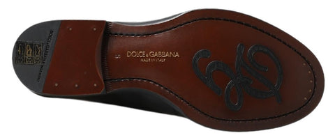 Black leather slipper loafers with stitched detailing by Dolce & Gabbana displayed on a plain background.