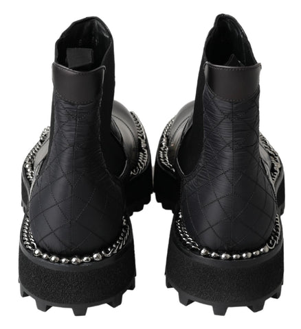 Black leather slip-on stretch boots by Dolce & Gabbana with sleek design and elastic sides, shown on a model.
