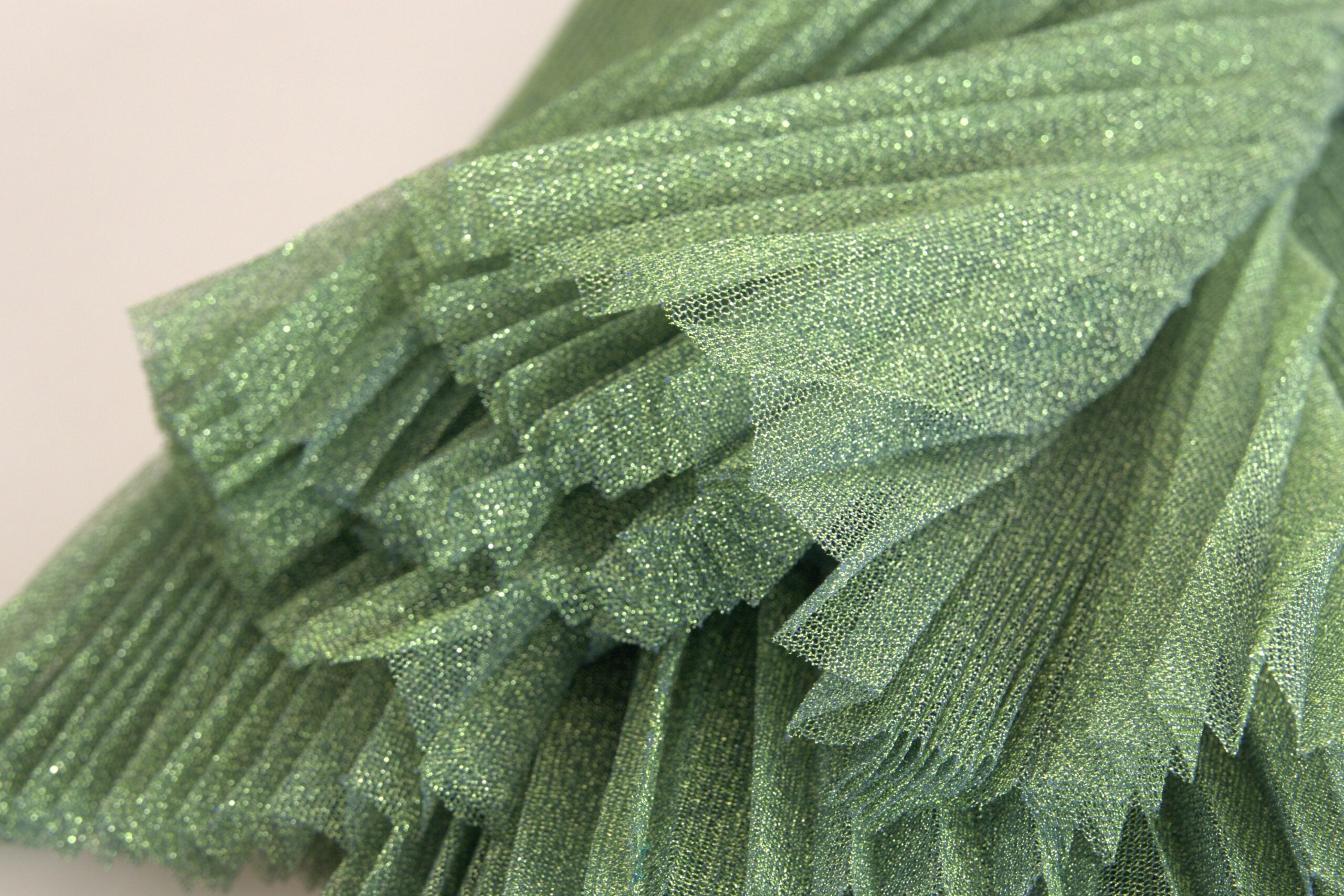 Metallic green high waist A-line pleated skirt by Dolce & Gabbana, featuring shiny fabric and elegant pleats.
