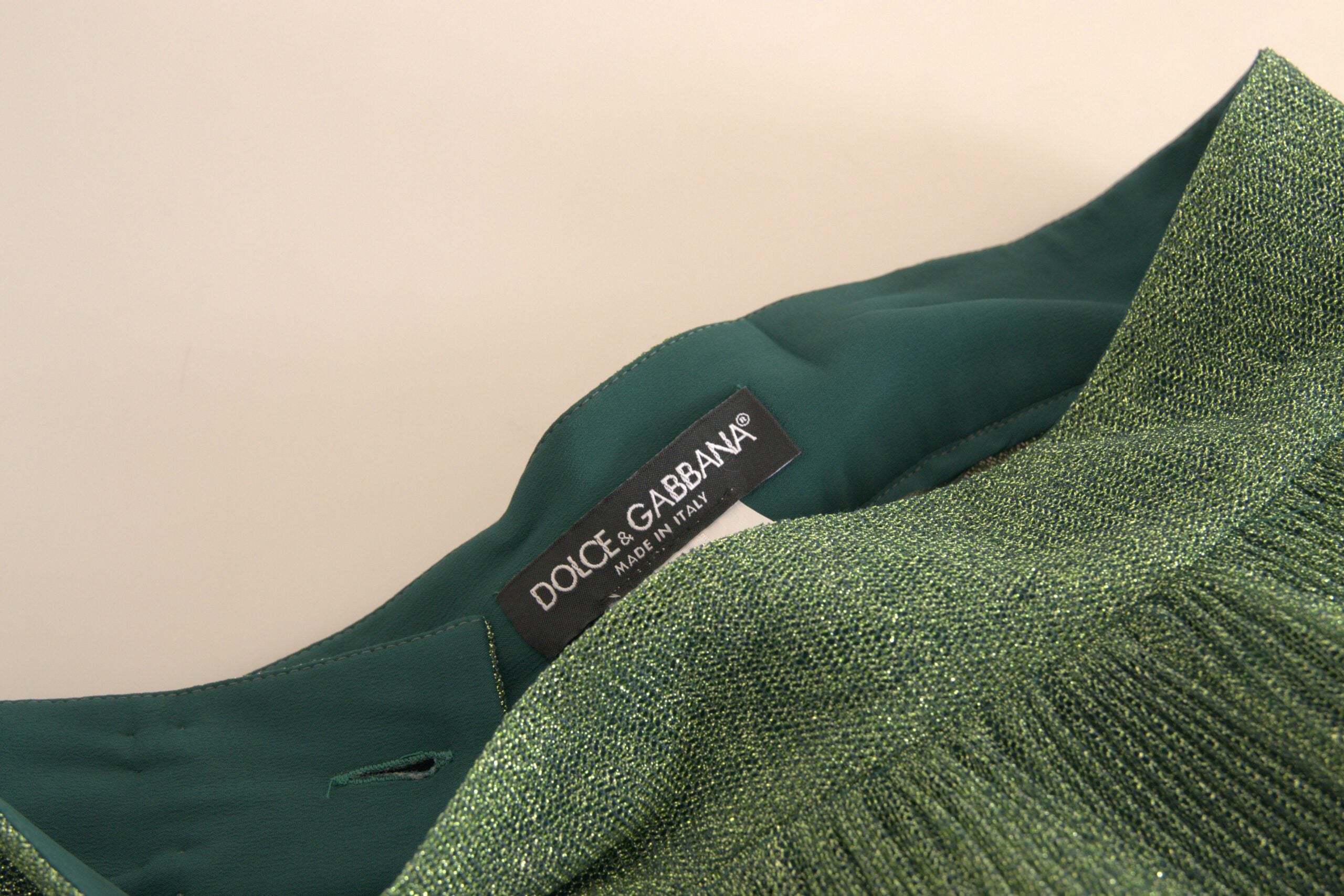 Metallic green high waist A-line pleated skirt by Dolce & Gabbana, shown in a close-up image highlighting the fabric and pleats.