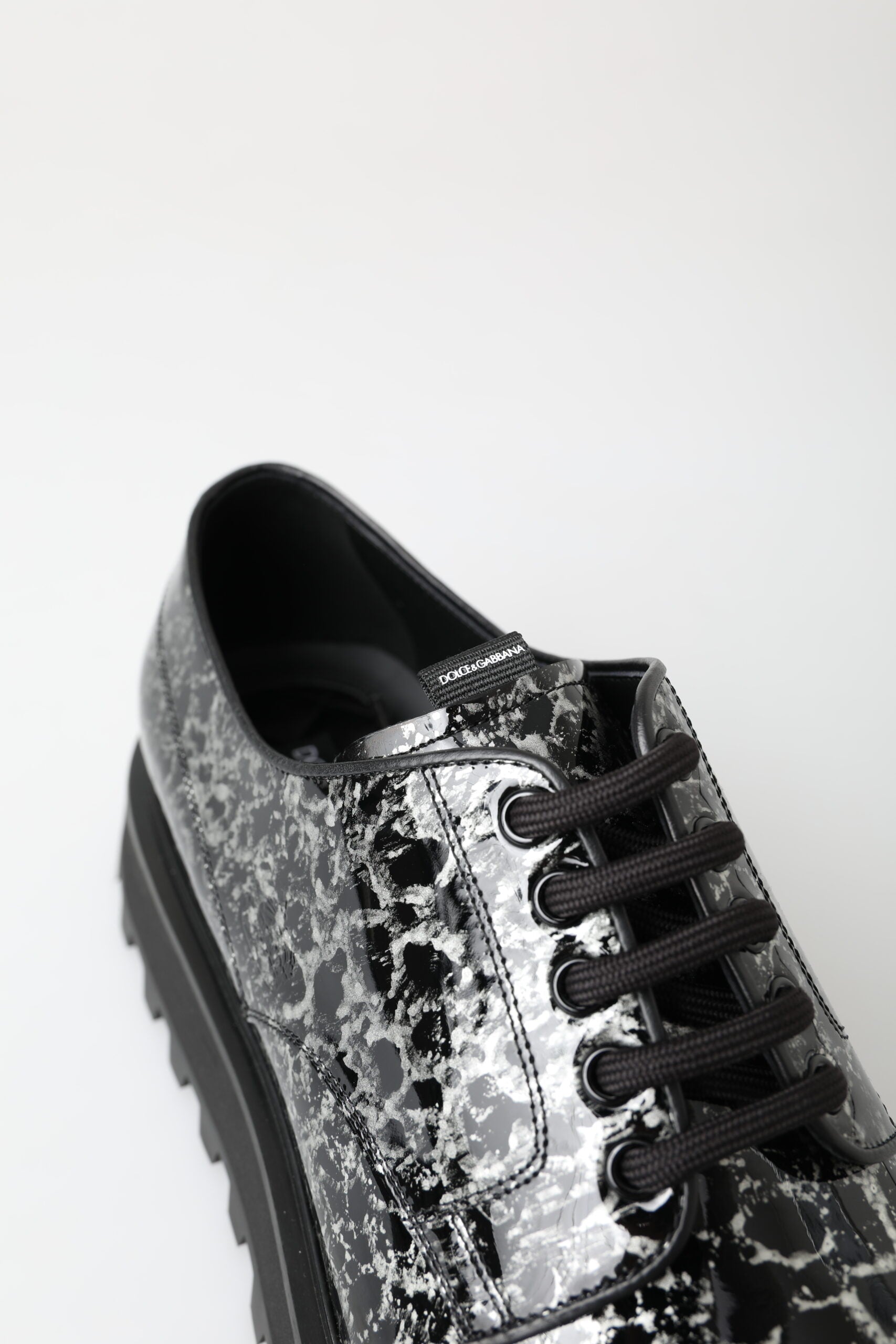Black and white Derby patent leather shoes by Dolce & Gabbana with sleek design and polished finish.