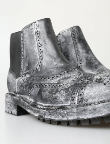 Black and gray leather ankle boots by Dolce & Gabbana with sleek design and pointed toes, shown in a close-up image.
