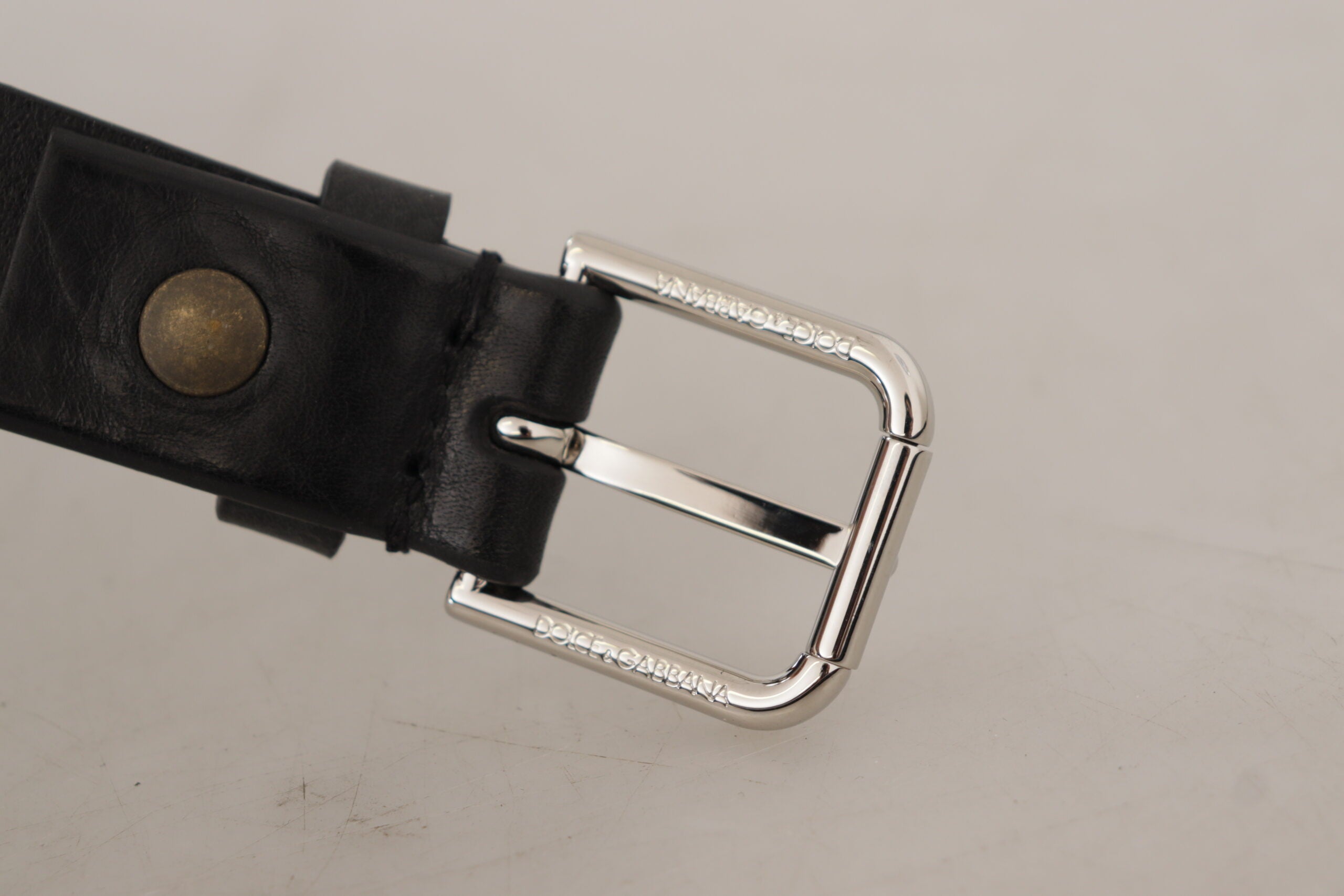 Black calf leather belt with silver tone logo metal buckle by Dolce & Gabbana, featuring a sleek and stylish design.