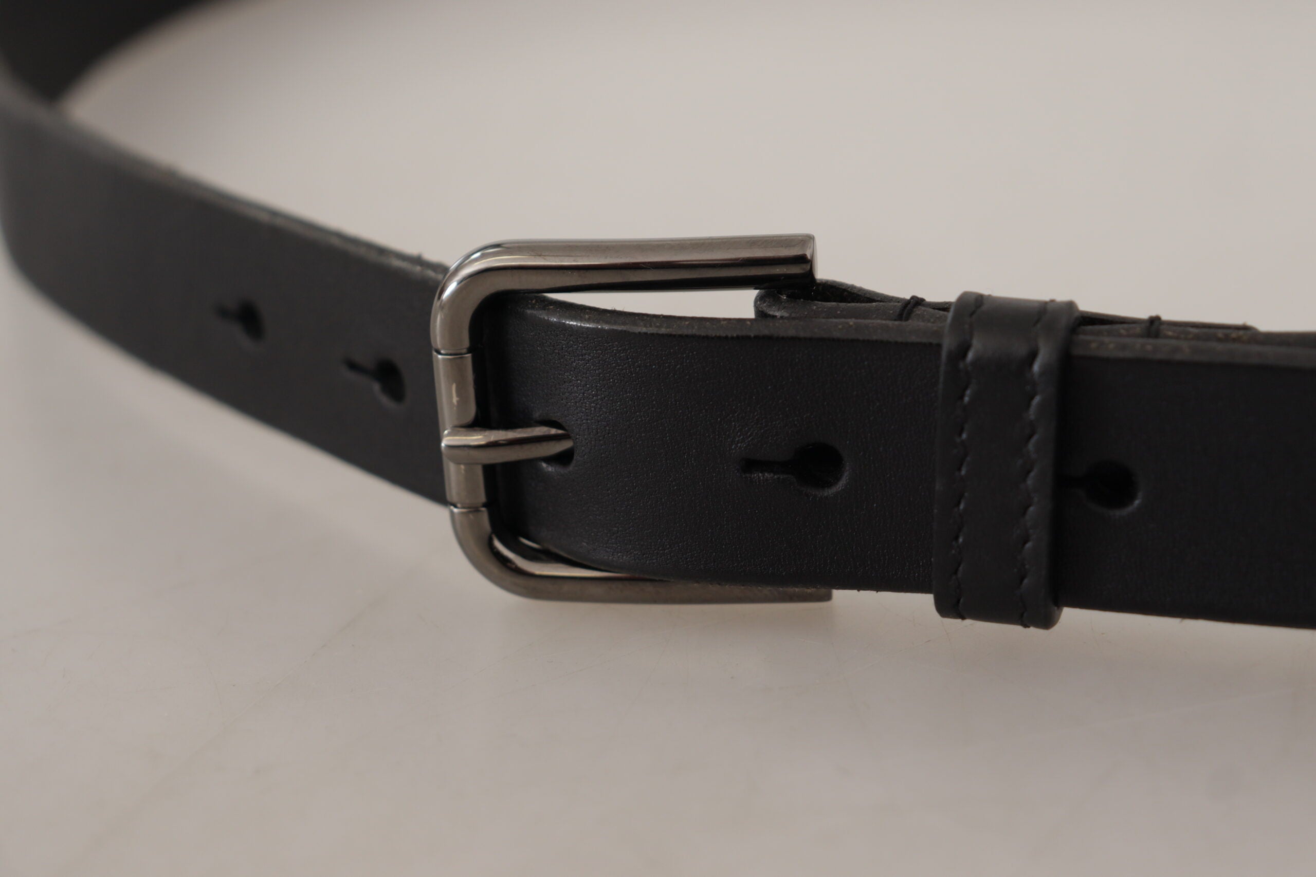 Black calf leather belt with engraved metal buckle and Dolce & Gabbana logo, stylish accessory for men.
