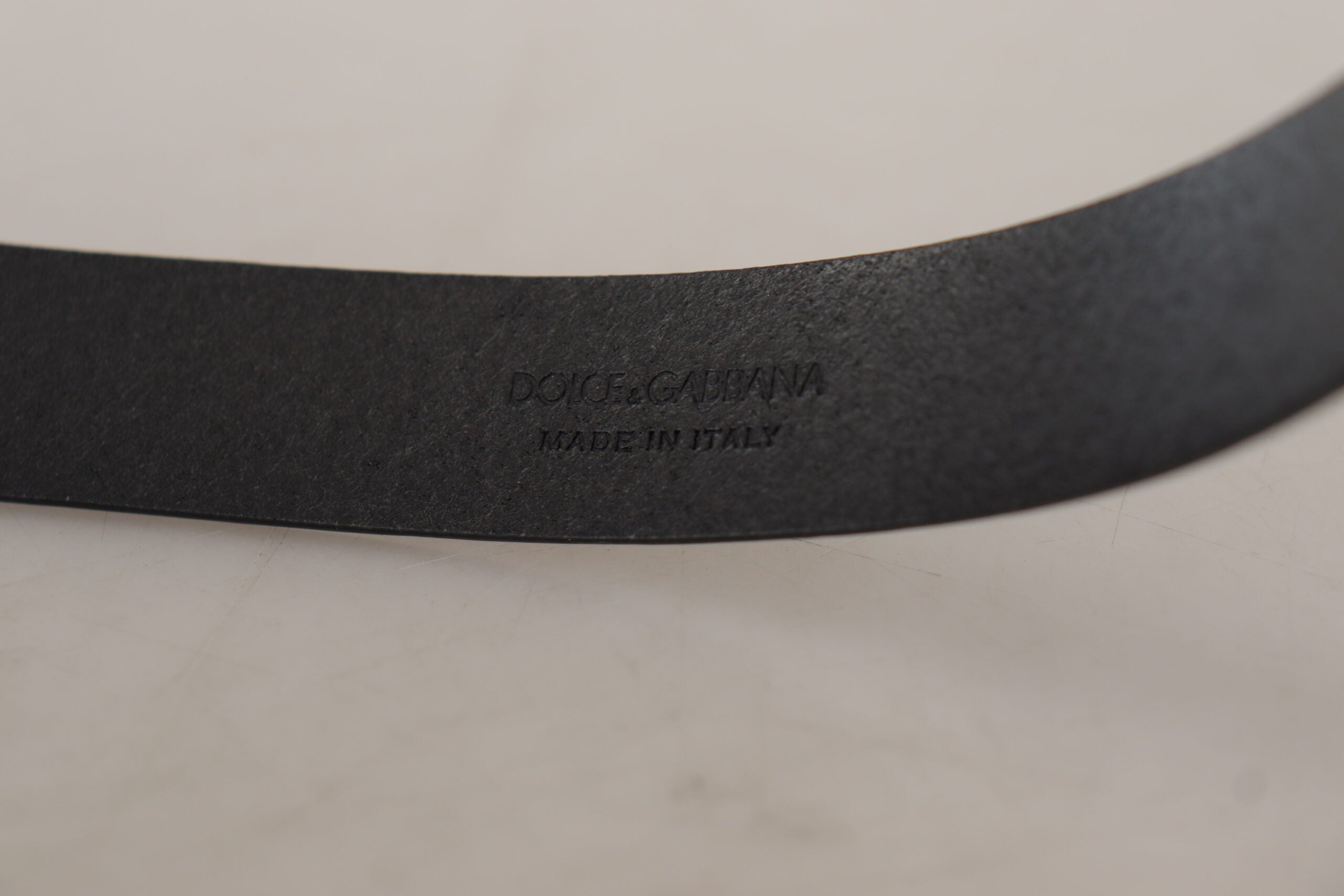 Black calf leather belt with classic logo and metal buckle from Dolce & Gabbana, featuring smooth leather and stylish design.