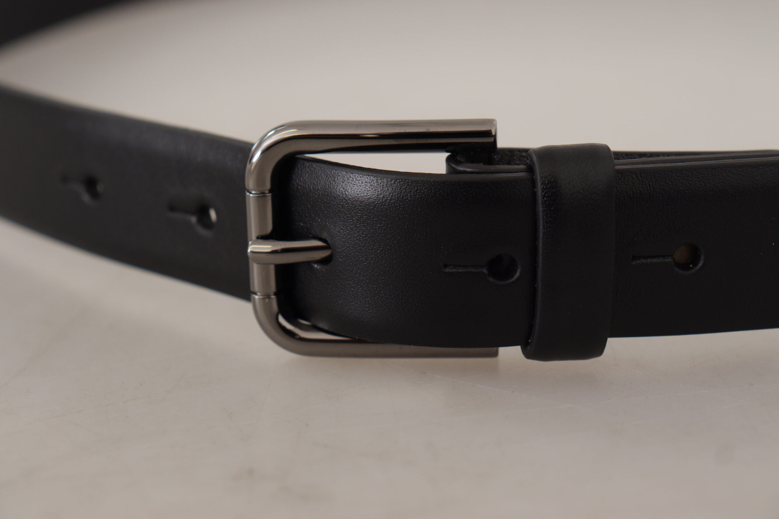 Black calf leather belt with classic logo and metal buckle by Dolce & Gabbana, featuring sleek design and smooth finish.