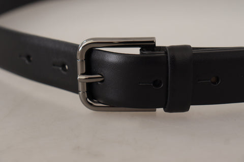 Black calf leather belt with classic logo and metal buckle by Dolce & Gabbana, featuring sleek design and smooth finish.