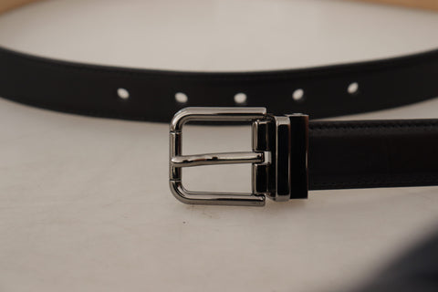 Black calf leather belt with engraved metal buckle and Dolce & Gabbana logo, stylish accessory for men.