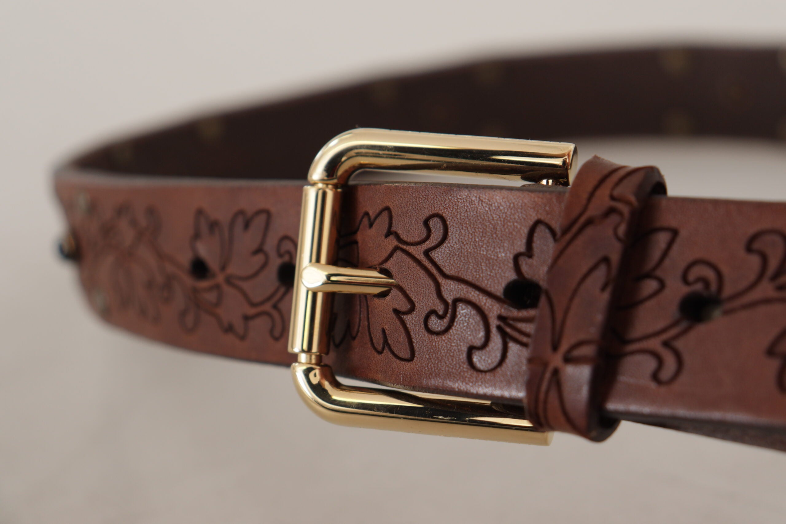 Brown leather floral studded belt with metal buckle from Dolce & Gabbana, featuring intricate floral detailing and metallic accents.