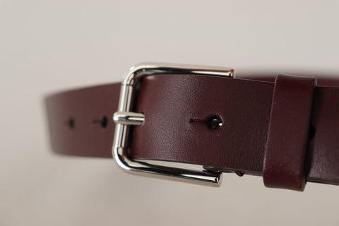 Maroon calf leather belt with silver tone metal buckle from Dolce & Gabbana, featuring smooth leather and classic design.