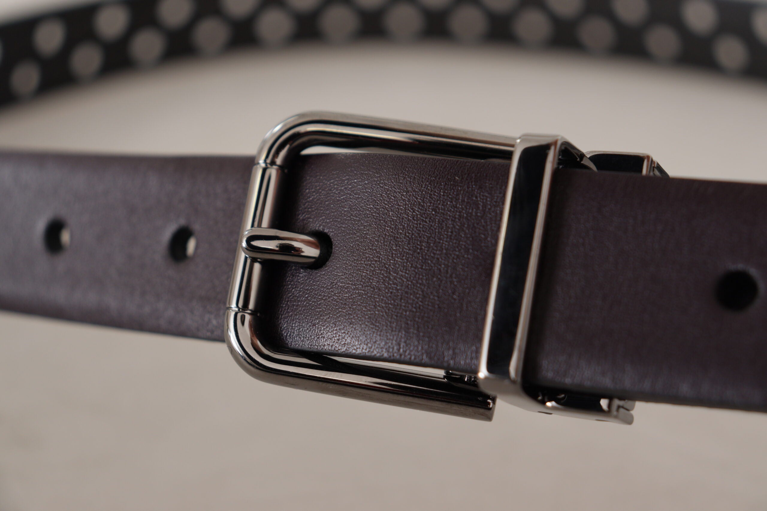 Dark purple Dolce & Gabbana leather belt with perforated design and metal buckle, stylish accessory for men and women.