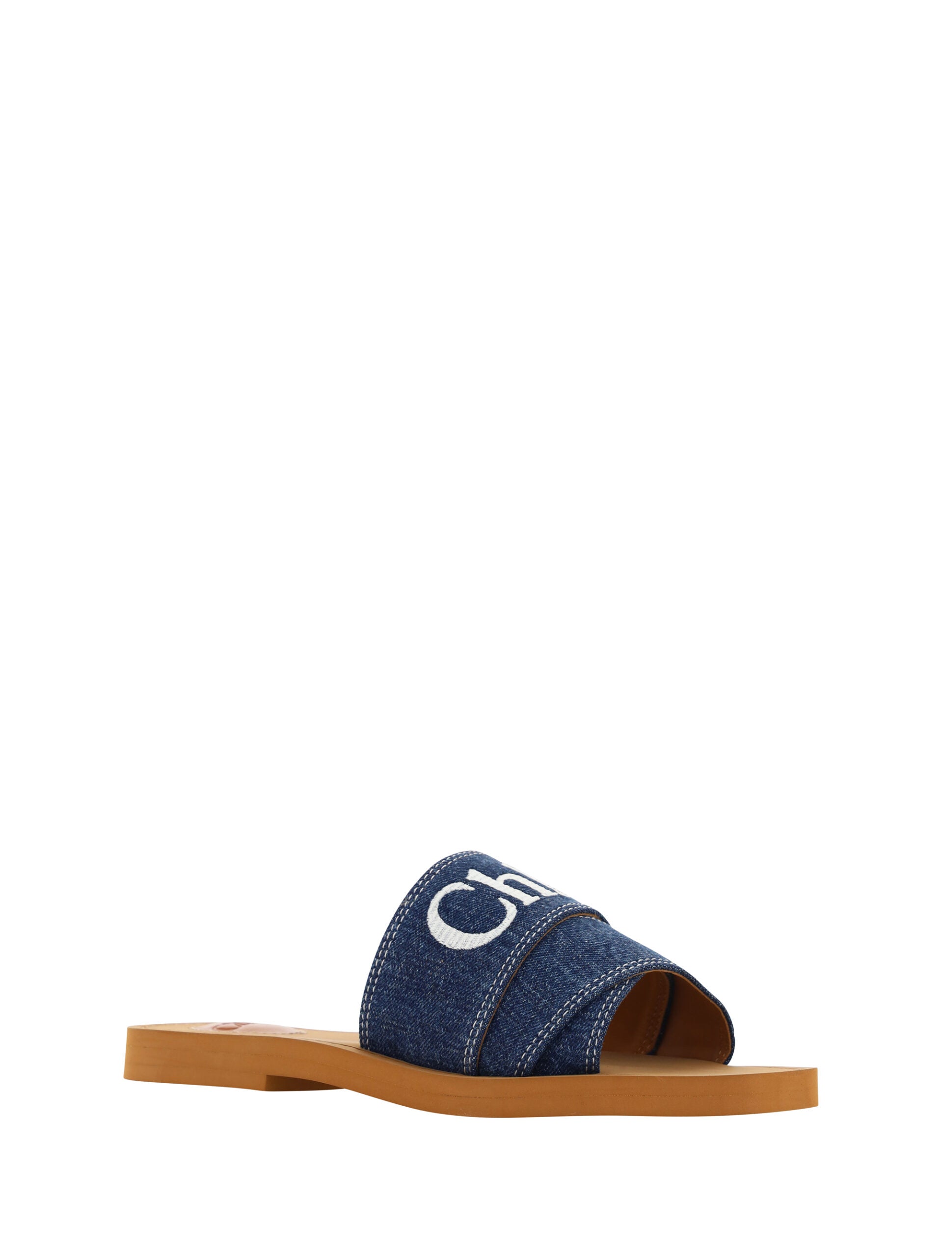 Chloé denim blue cotton slides with woody sandal soles, featuring casual slip-on design and comfortable straps.