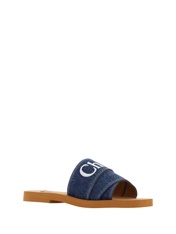 Chloé denim blue cotton slides with woody sandal soles, featuring casual slip-on design and comfortable straps.