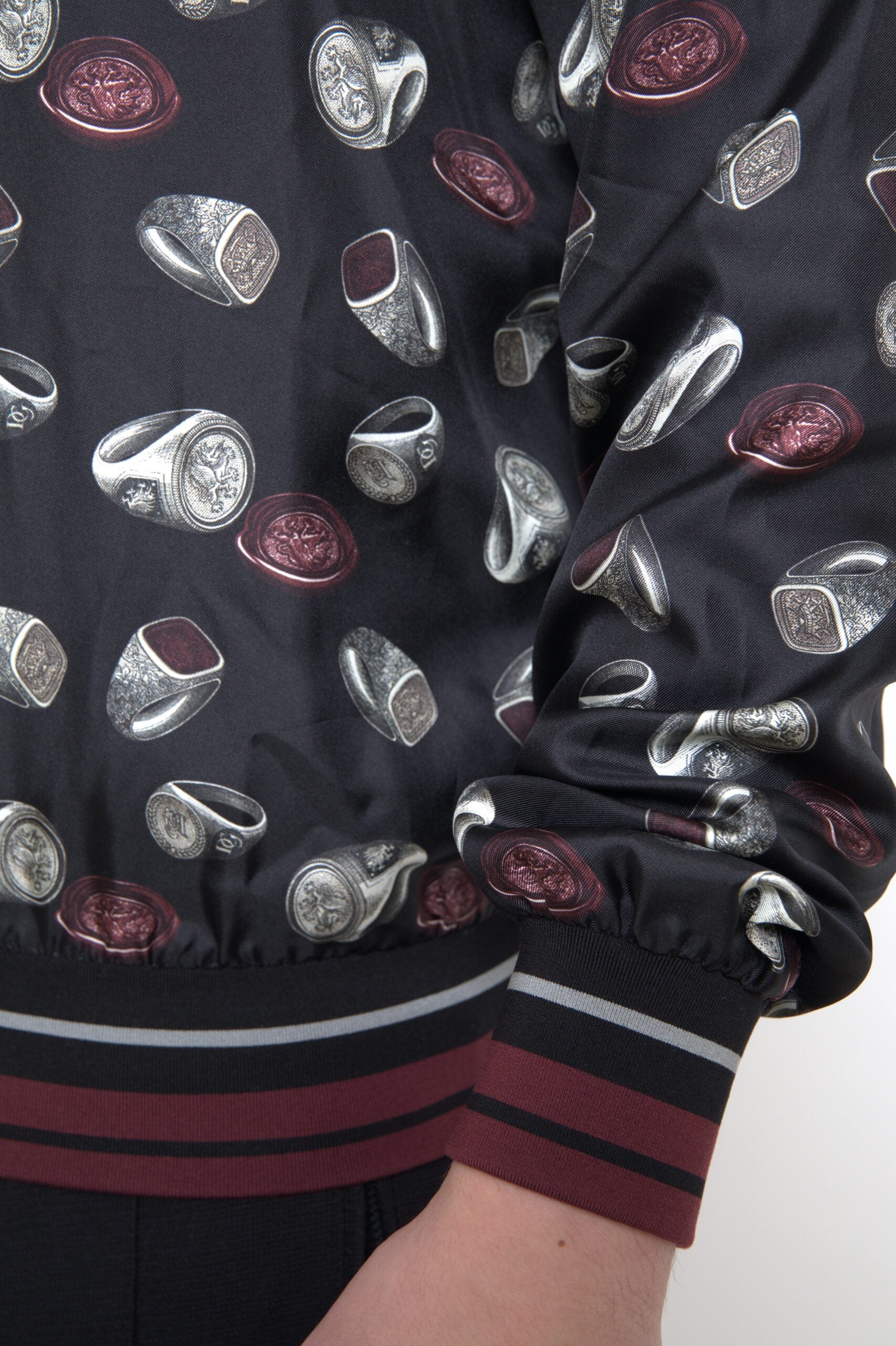 Black silk crewneck sweater with ring print design by Dolce & Gabbana, featuring a close-up view of the fabric and print details.