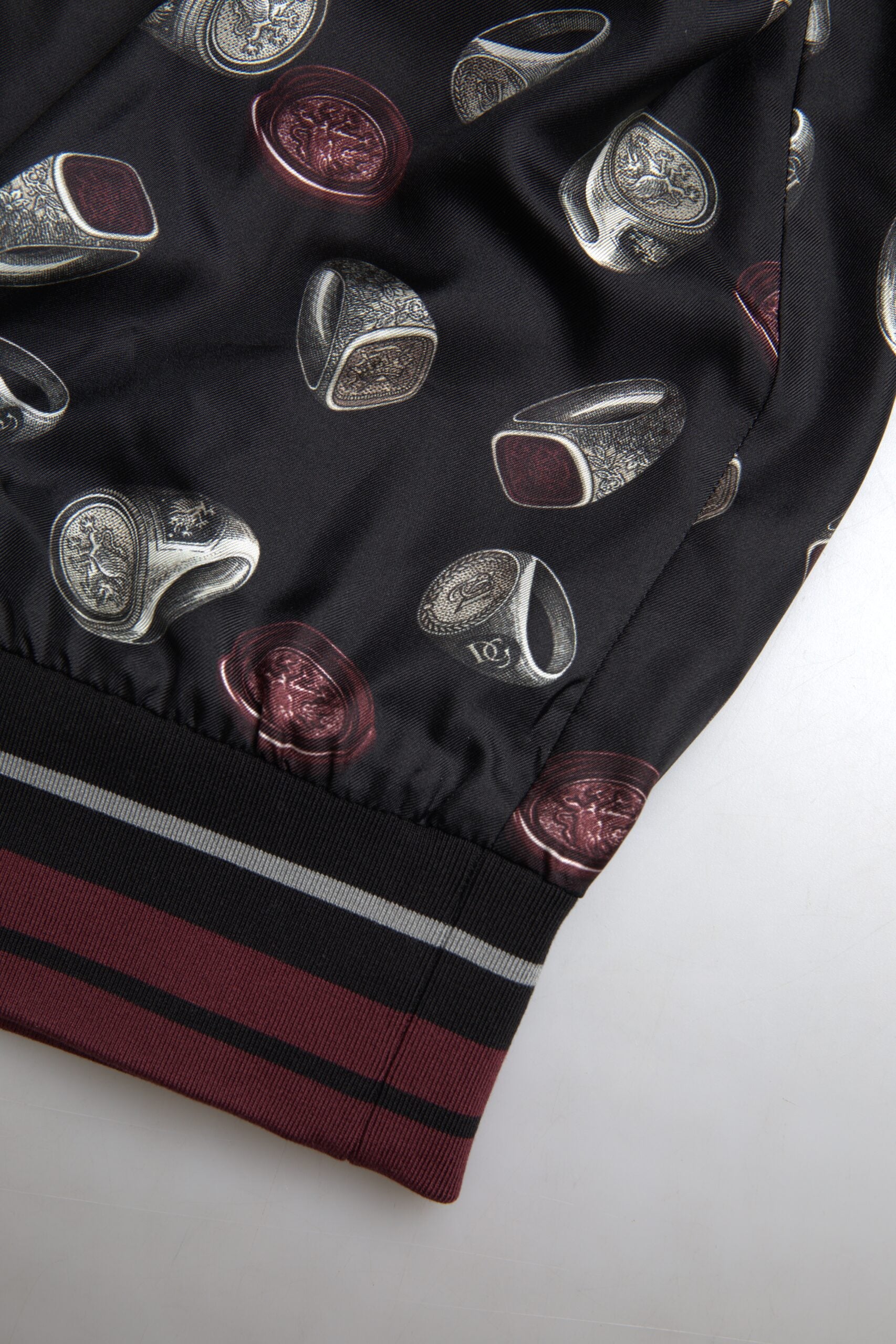 Black silk crewneck sweater with ring print design by Dolce & Gabbana, shown on a plain background.