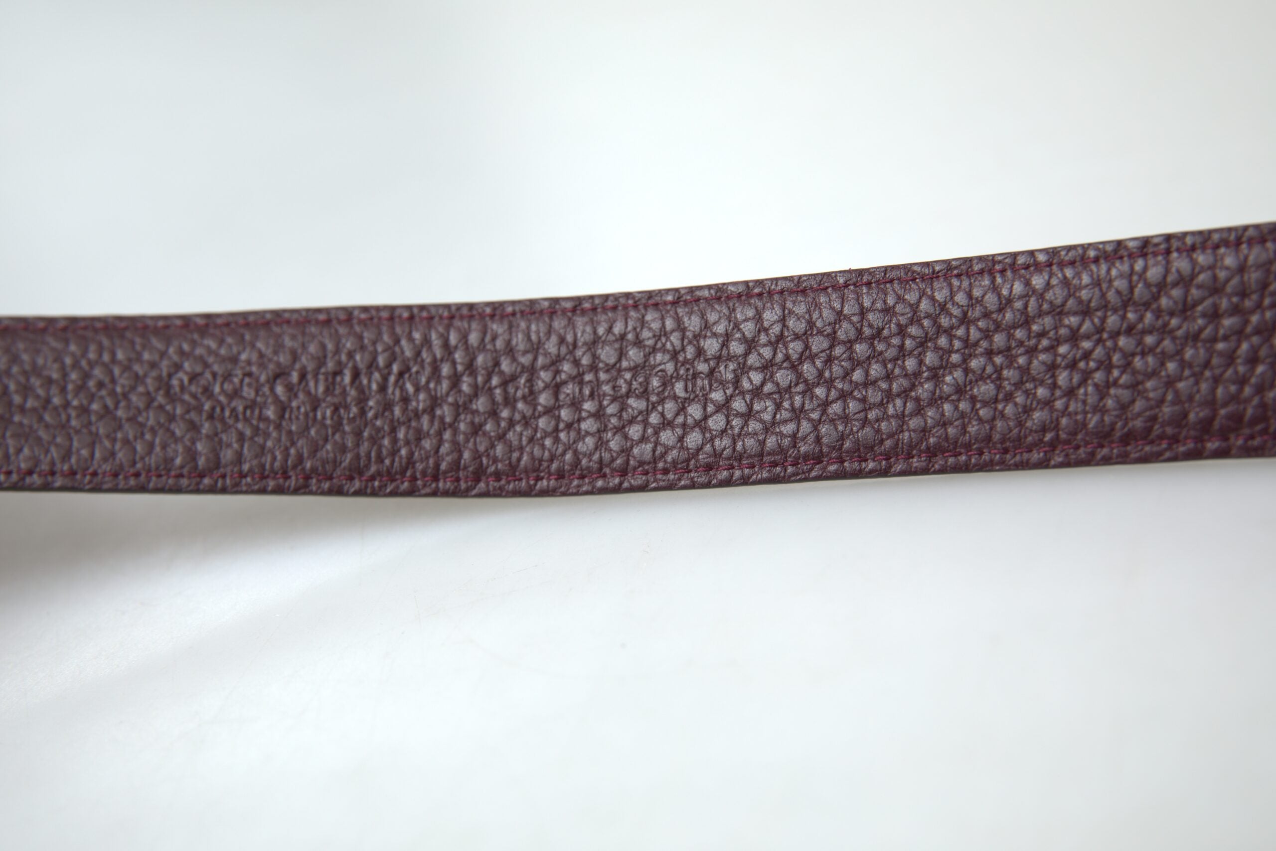 Brown leather men's belt with metal buckle from Dolce & Gabbana, featuring a sleek design and adjustable strap.