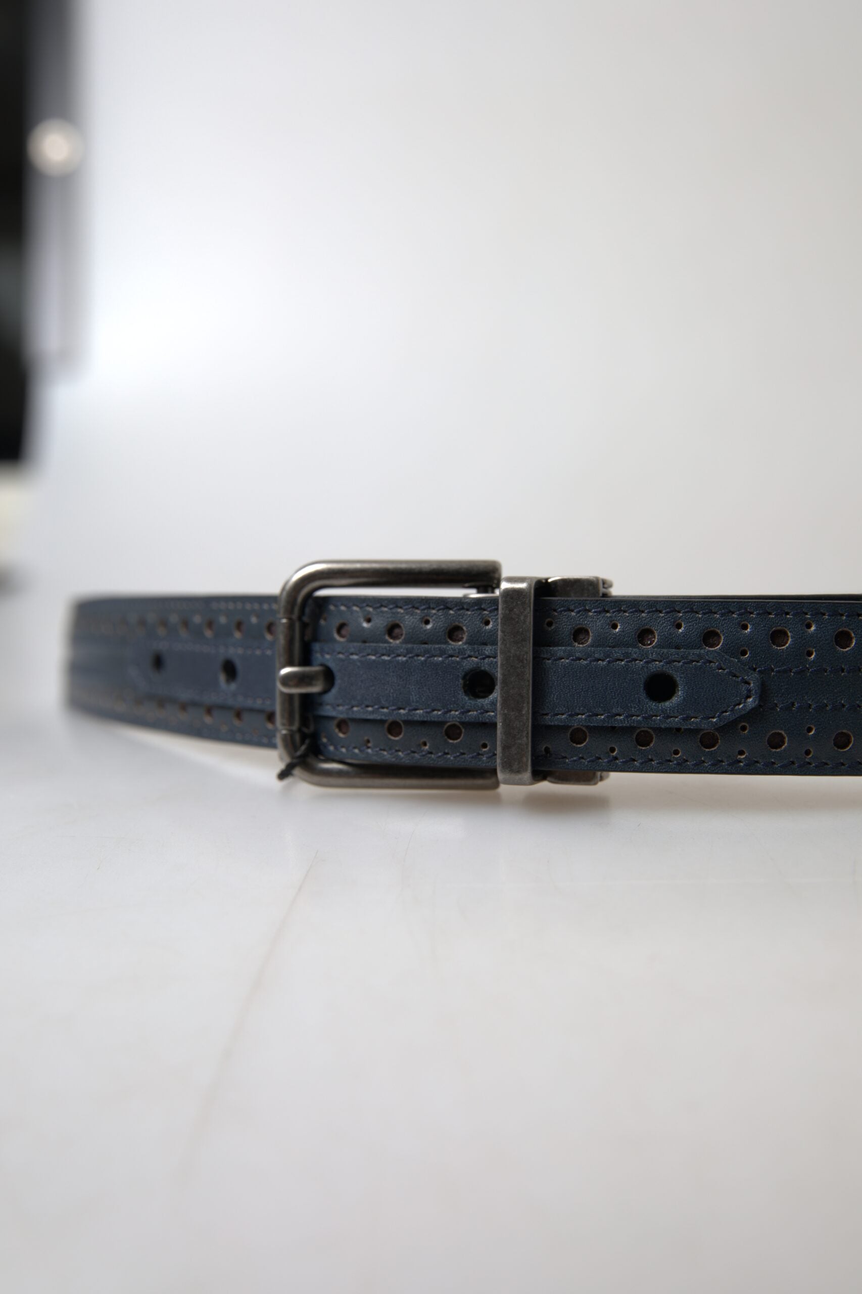 Blue leather belt with perforated metal buckle from Dolce & Gabbana, featuring a stylish and modern design.