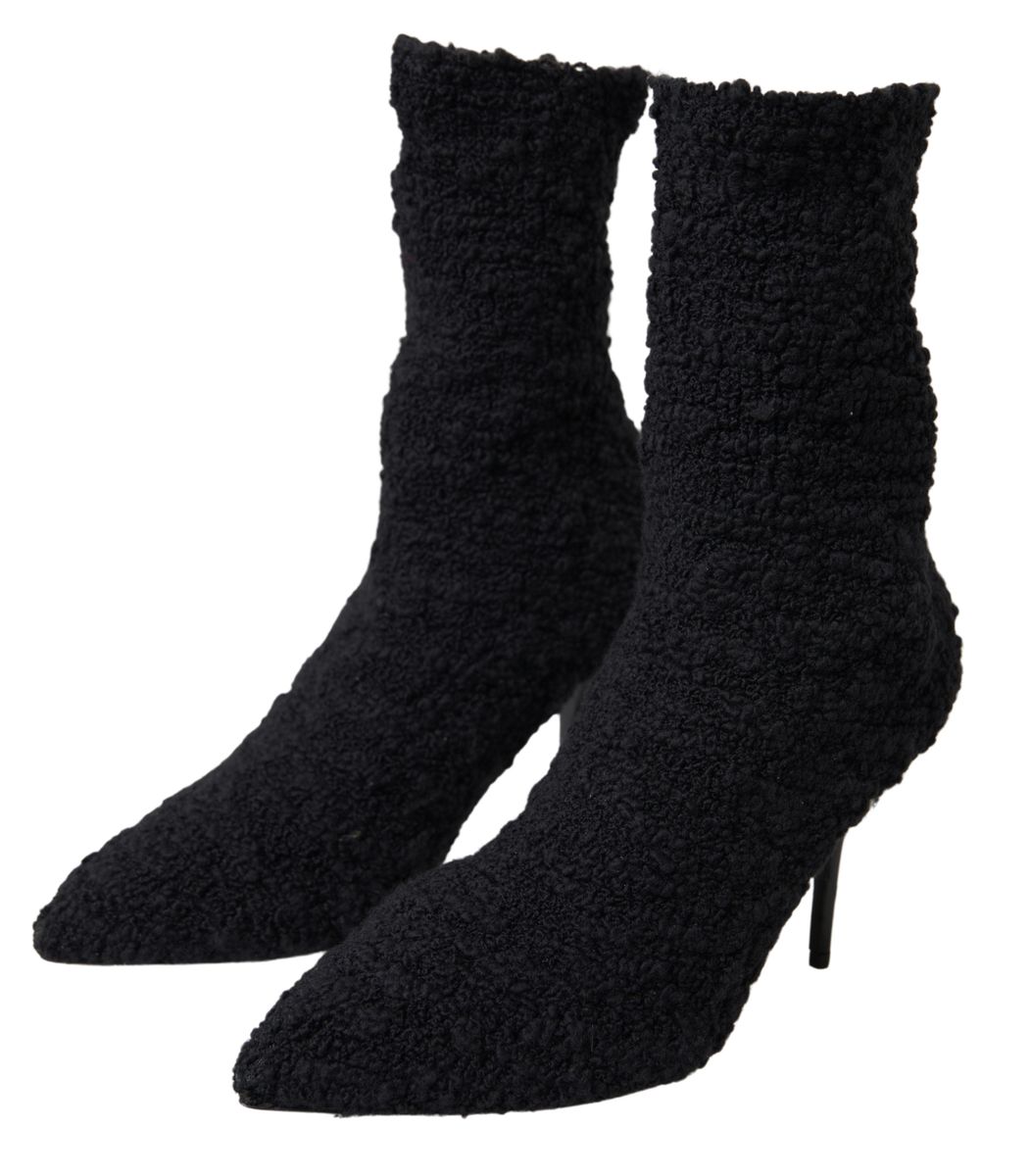 Black Dolce & Gabbana stiletto heels and mid calf boots with pointed toes and sleek design on a white background.