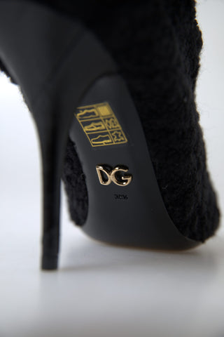 Pair of black stiletto heel mid-calf boots by Dolce & Gabbana, featuring smooth leather and sleek design.