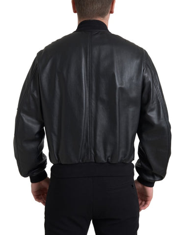 Black leather blouson bomber jacket with full zip and ribbed cuffs, by Dolce & Gabbana, shown on a neutral background.
