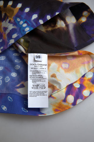 Dolce & Gabbana men's Luminaire Print cotton polo shirt displayed on a hanger, featuring a vibrant graphic design.