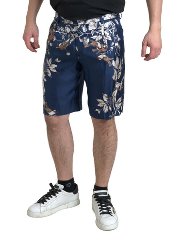 Blue floral print silk Bermuda shorts for men by Dolce & Gabbana, featuring a stylish floral pattern and tailored fit.