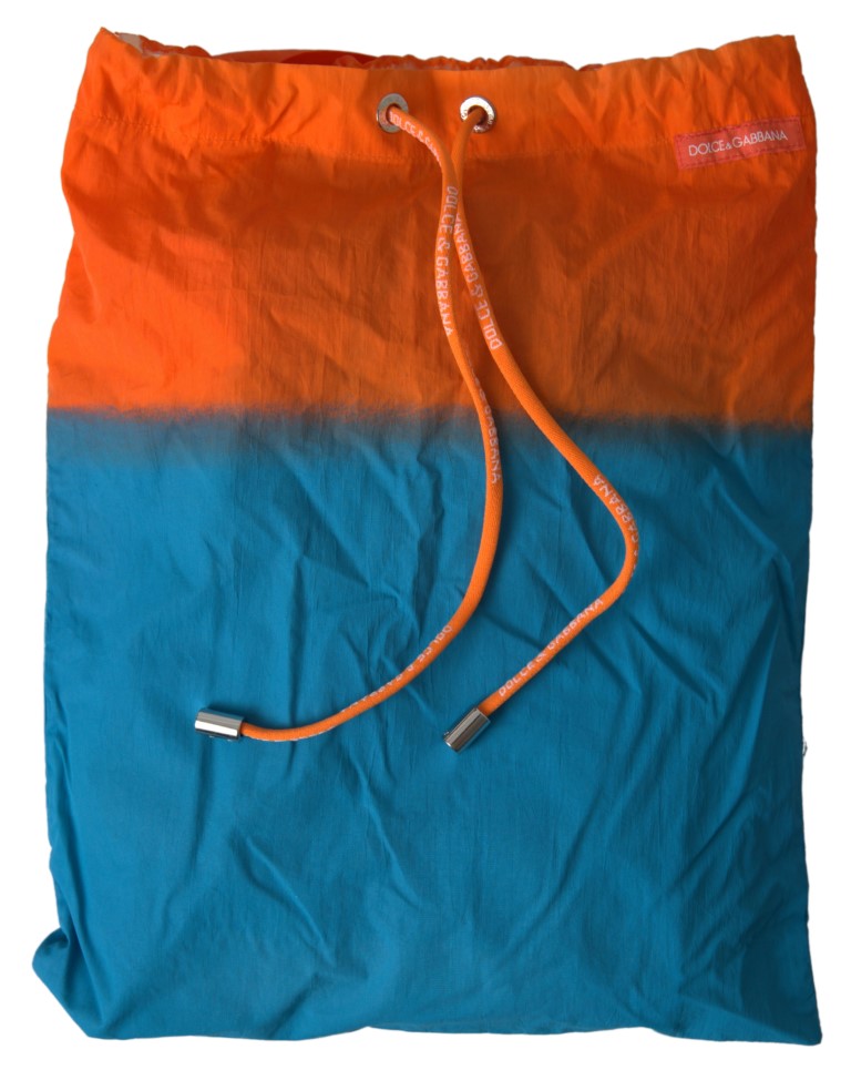 Orange and blue gradient Dolce & Gabbana beachwear swimwear shorts displayed on a model, featuring a stylish and vibrant design.