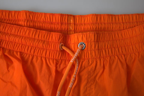 Orange and blue gradient Dolce & Gabbana beachwear swimwear shorts displayed on a model.