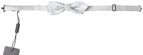 Gray silk adjustable men's bow tie with a papillon style, designed by Dolce & Gabbana, shown on a flat surface.