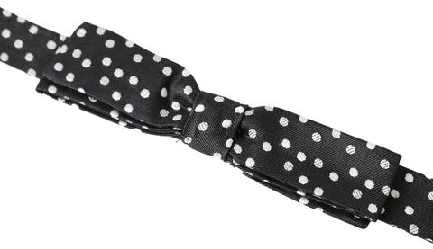 Black polka dot silk adjustable men's bow tie with a papillon style, by Dolce & Gabbana, shown on a white background.