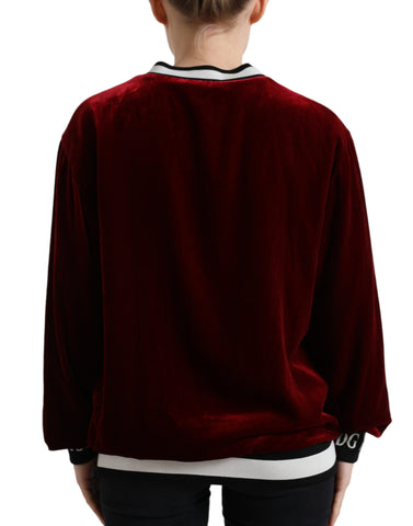 Dolce & Gabbana Bordeaux velvet crew neck pullover sweater displayed on a hanger, showcasing its rich color and soft texture.