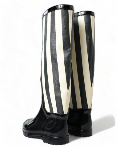 Black rubber knee-high flat boots by Dolce & Gabbana, featuring sleek design and sturdy soles for stylish comfort.