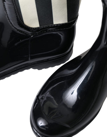 Black rubber knee-high flat boots by Dolce & Gabbana, featuring a sleek design and smooth finish.