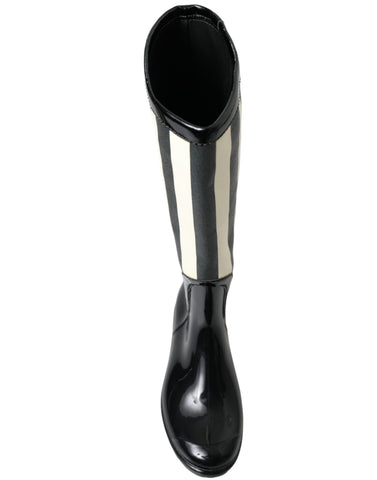 Black rubber knee-high flat boots by Dolce & Gabbana, featuring a sleek design and sturdy flat soles.