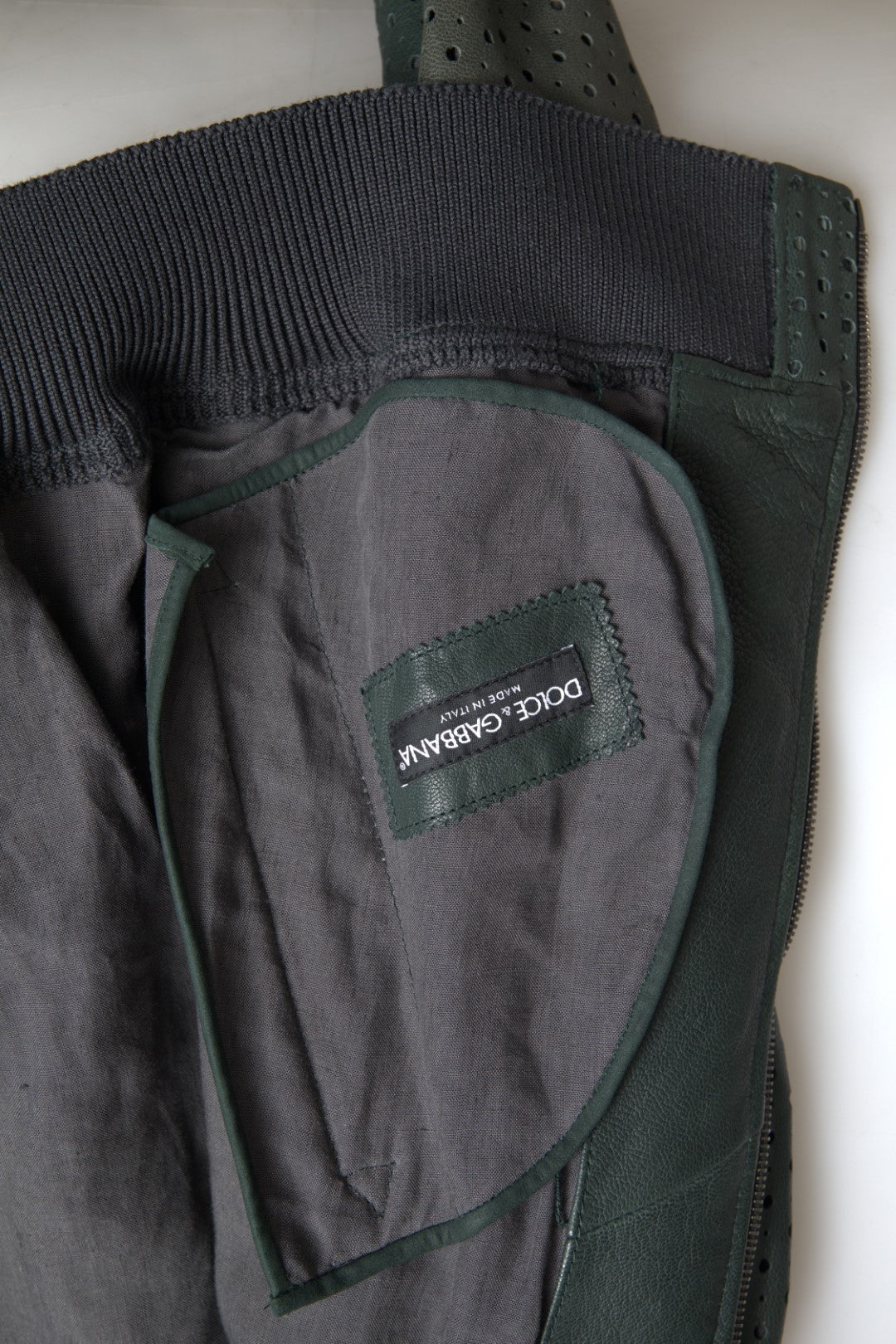 Green perforated leather bomber jacket by Dolce & Gabbana, featuring a stylish design with textured perforations and ribbed cuffs.