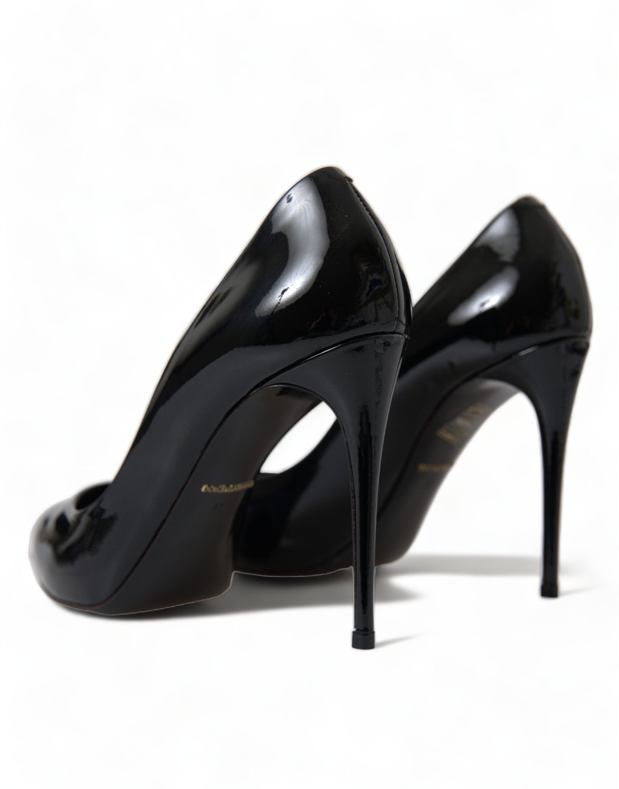 Black patent leather pumps with stiletto heels from Dolce & Gabbana, showcasing elegant pointed toe shoes.