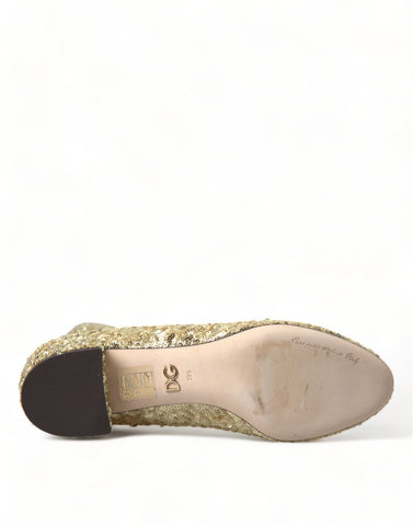 Gold sequined short stretch boots by Dolce & Gabbana shown on a model, featuring a sleek design and shimmering finish.