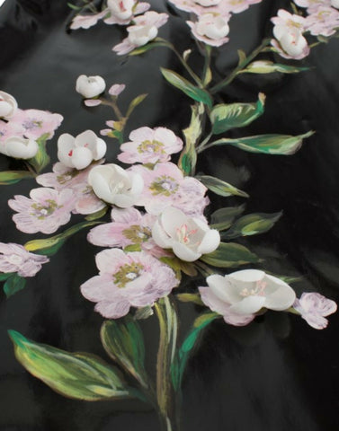 Black patent floral handpainted dress by Dolce & Gabbana, featuring a fitted silhouette and vibrant floral details.