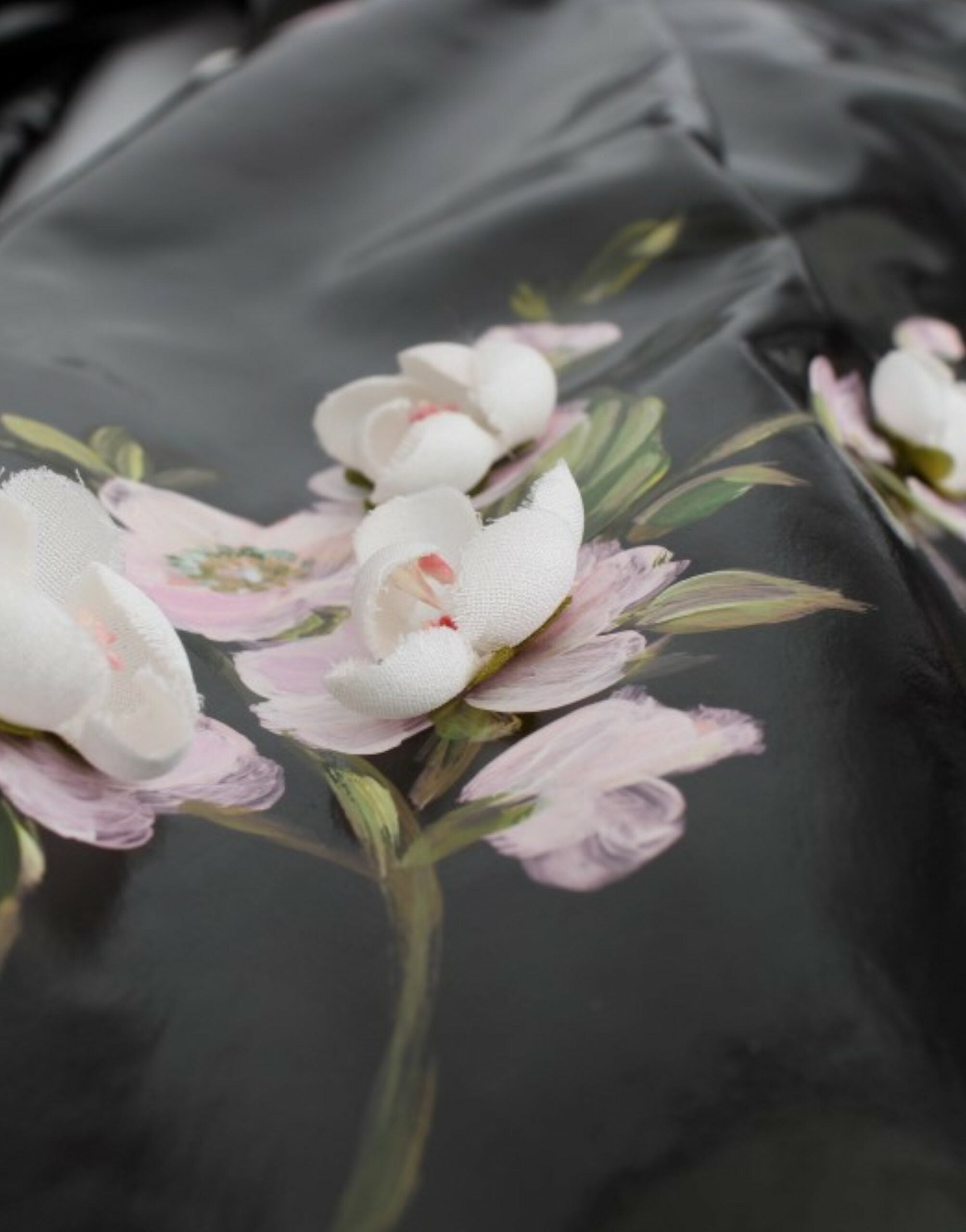 Black patent floral hand-painted dress by Dolce & Gabbana, featuring intricate floral designs on a sleek, glossy fabric.