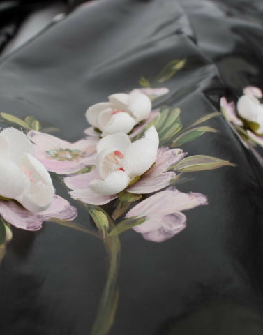 Black patent floral hand-painted dress by Dolce & Gabbana, featuring intricate floral designs on a sleek, glossy fabric.