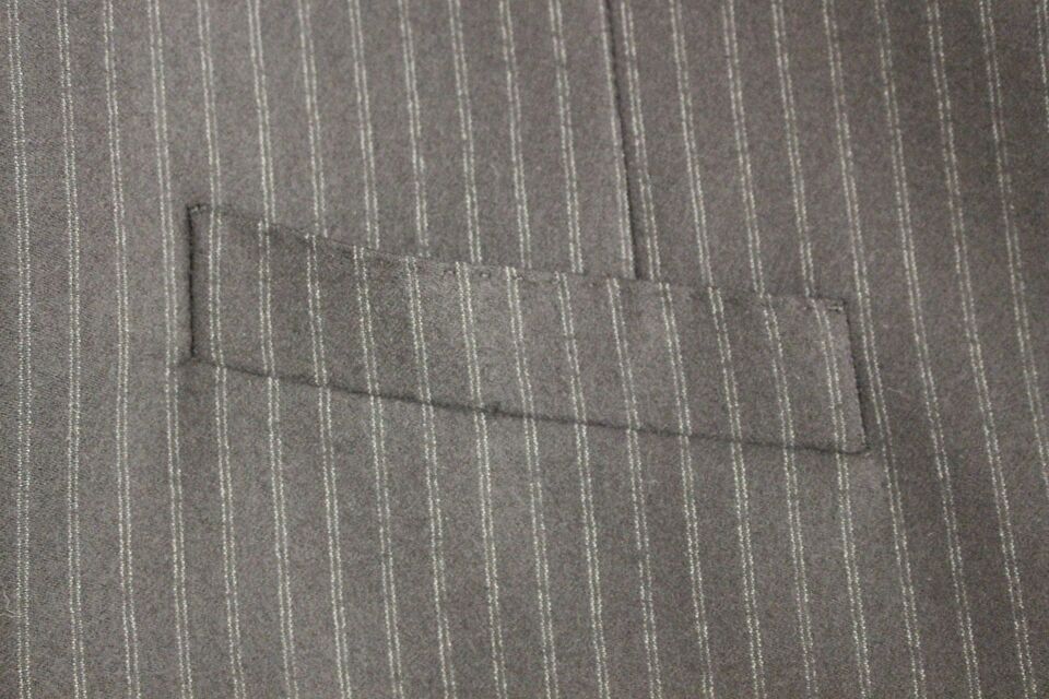 Black wool single-breasted vest with white stripe details from Dolce & Gabbana, shown on a hanger with a tailored fit.