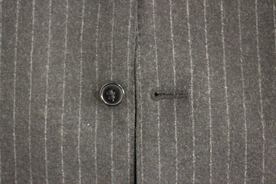 Gray striped wool Dolce & Gabbana logo vest gilet hanging on a wooden hanger, showcasing its textured fabric and stylish design.
