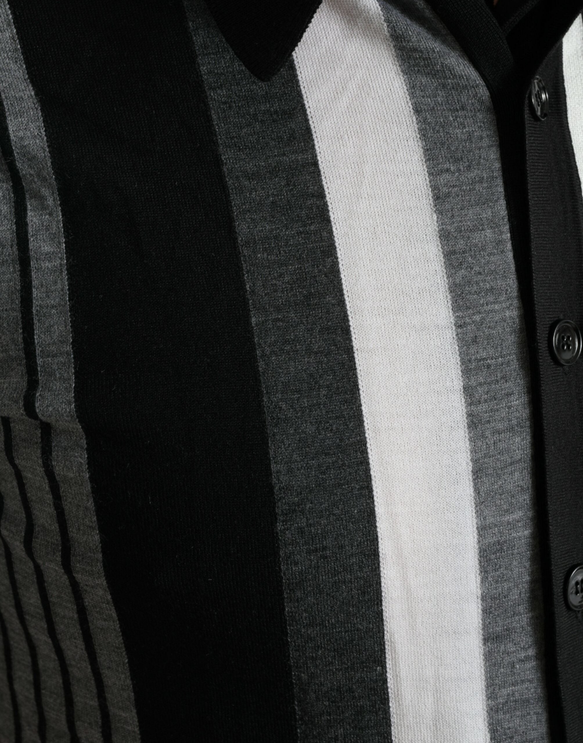 Black and white Dolce & Gabbana jumper cardigan polo sweater laid flat, showcasing its classic design and knit texture.