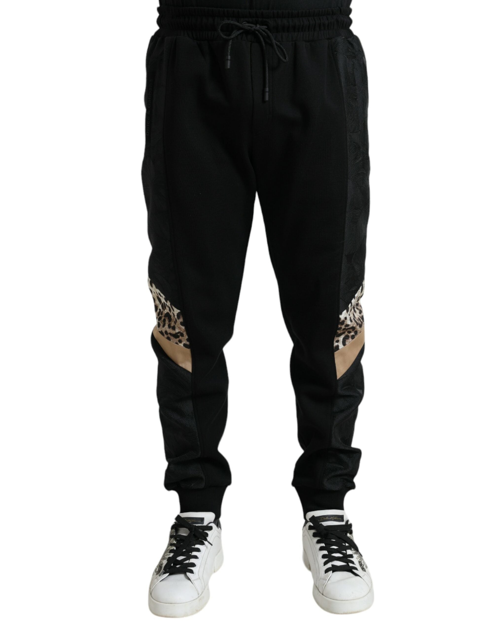 Black cotton slim stretch jogger pants by Dolce & Gabbana, showing a close-up of the fitted waistband and tapered leg design.