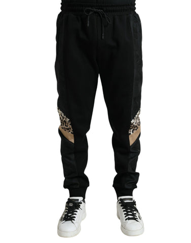 Black cotton slim stretch jogger pants by Dolce & Gabbana, showing a close-up of the fitted waistband and tapered leg design.