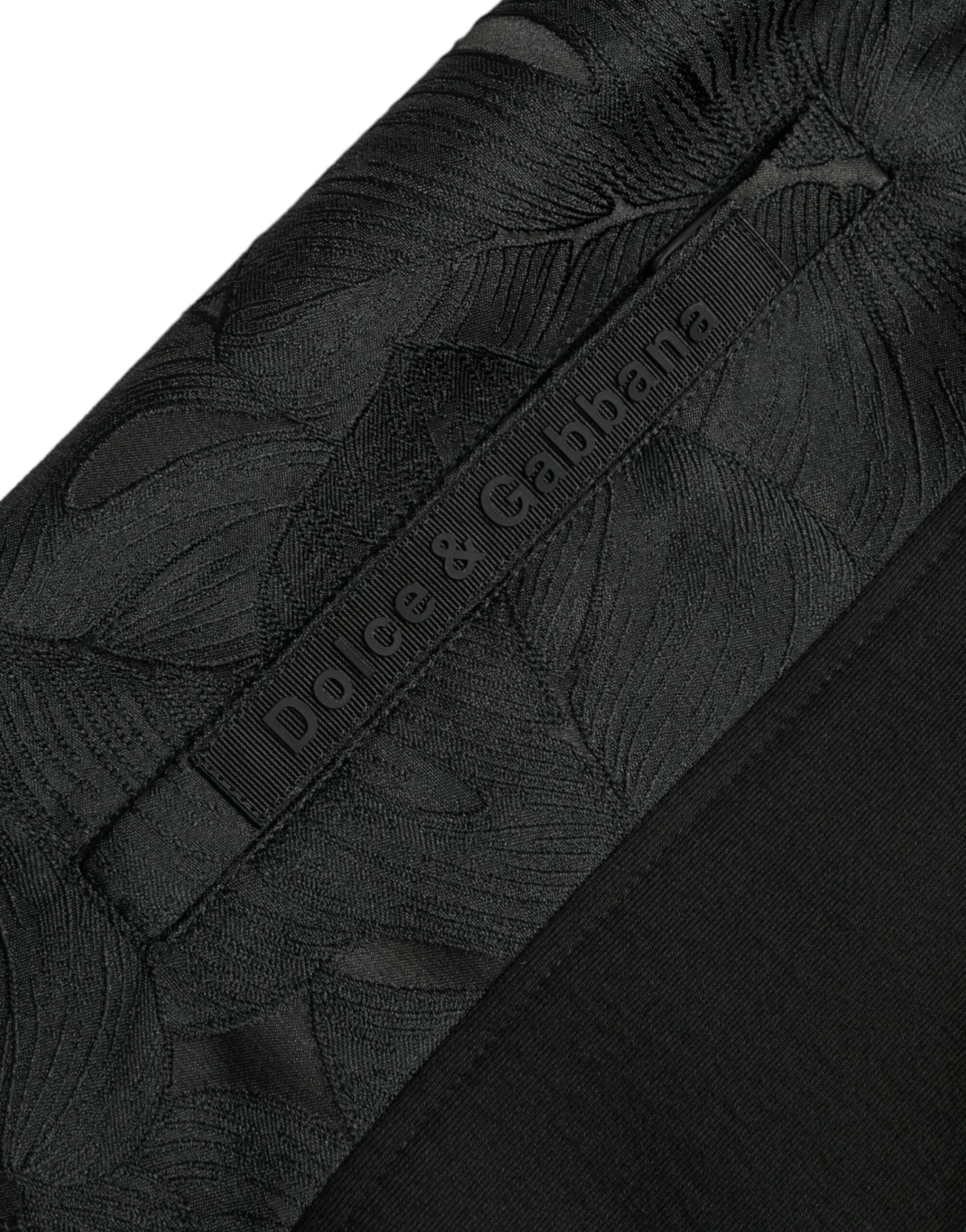 Black cotton slim stretch jogger pants by Dolce & Gabbana with tapered fit and elastic waistband, shown on a model.