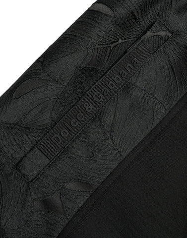 Black cotton slim stretch jogger pants by Dolce & Gabbana with tapered fit and elastic waistband, shown on a model.