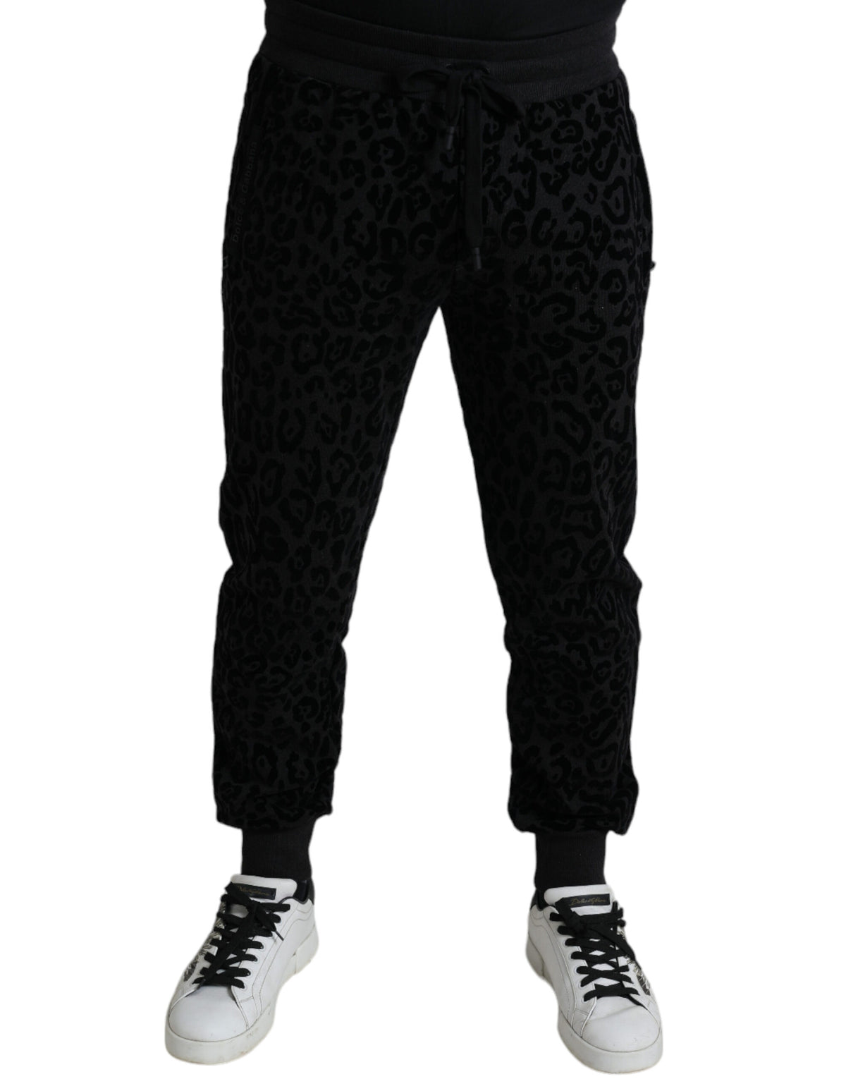 Black leopard print cotton slim fit jogger pants by Dolce & Gabbana with elastic waistband and tapered cuffs.
